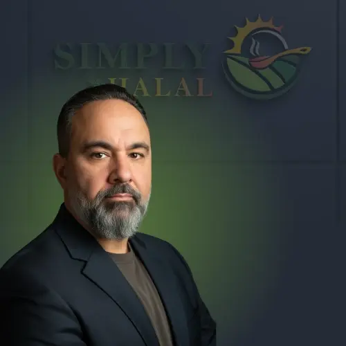 Professional portrait of a man with a beard wearing a dark blazer, set against a Simply Halal logo background.