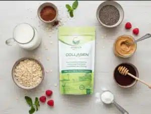 A top-down view of all the ingredients for Overnight Chocolate Collagen Oats spread out on a white surface. The Simply Halal Collagen Peptides product bag is centered as the main focus. Surrounding it are small bowls or piles of the other ingredients: rolled oats, cocoa powder, chia seeds, maple syrup (in a small jar), peanut butter (in a small jar), and a container of unsweetened almond milk. This visual is arranged to show all components needed for the recipe.