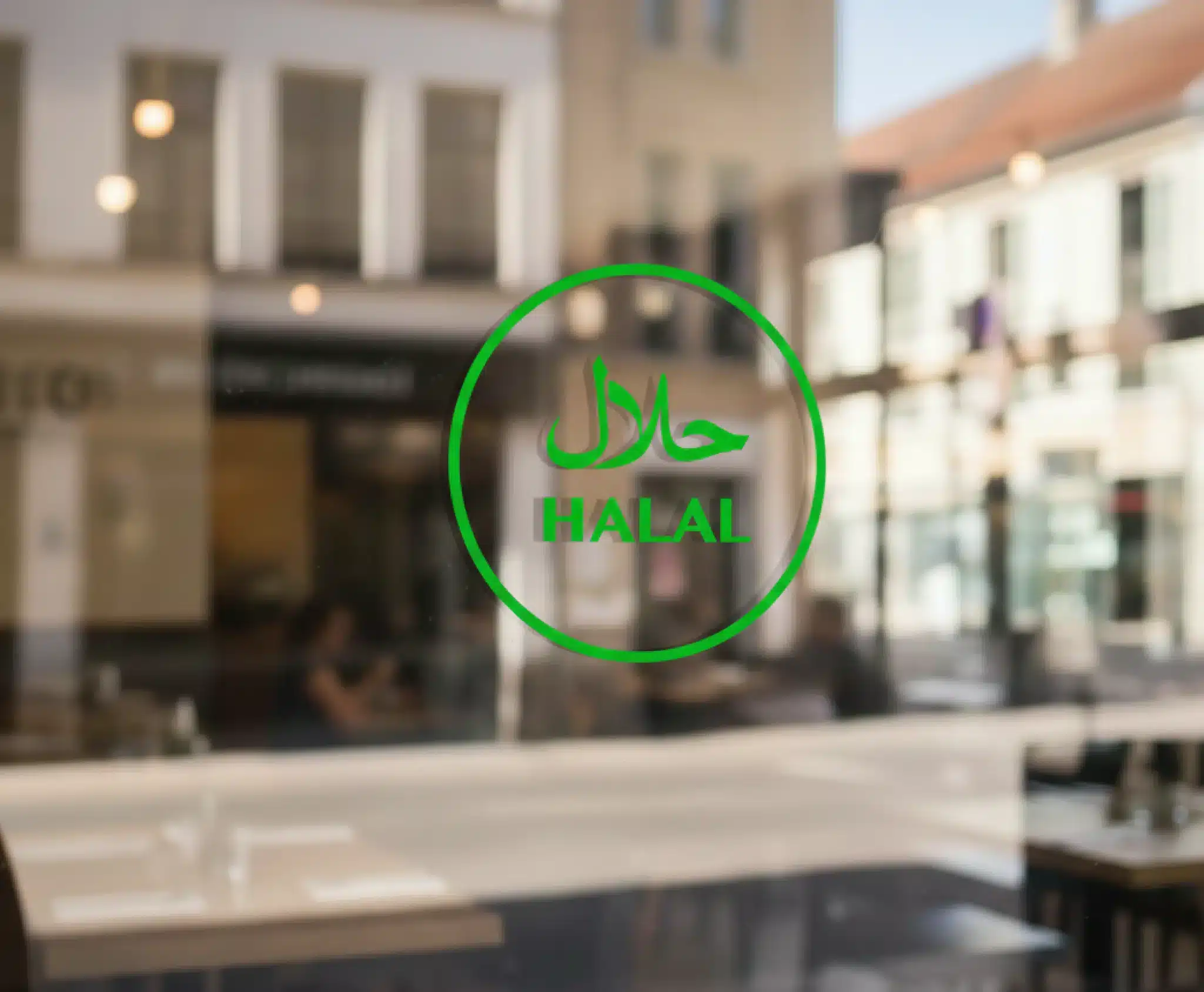 A close-up photograph of a clean, modern restaurant glass window featuring a large, vibrant green Halal certification logo. The logo includes the word 'Halal' in both elegant Arabic calligraphy (حلال) and bold English capital letters. The reflection on the glass shows a bright, sunlit outdoor setting, conveying a sense of transparency, trust, and premium quality.